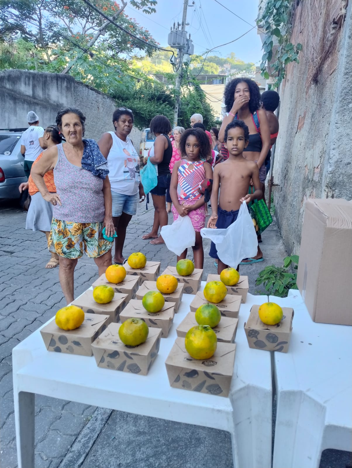 Distribuição de marmitas com laranjas para moradores